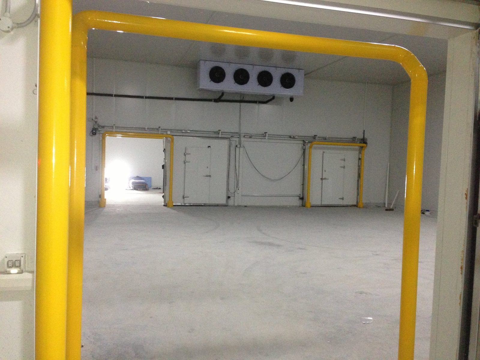 Industrial cold storage facility with hydrocarbon-safe yellow bollards